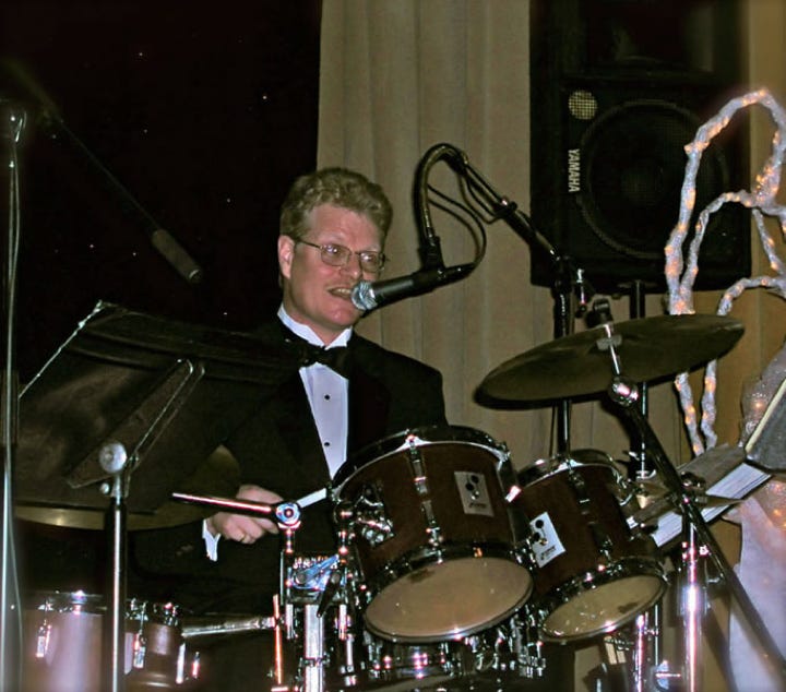 Energetic live band performance on stage with dynamic lighting at night.